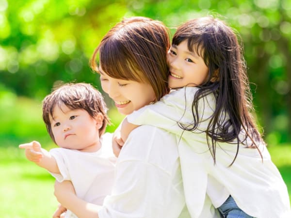 2人の子どもと公園で笑顔のママ